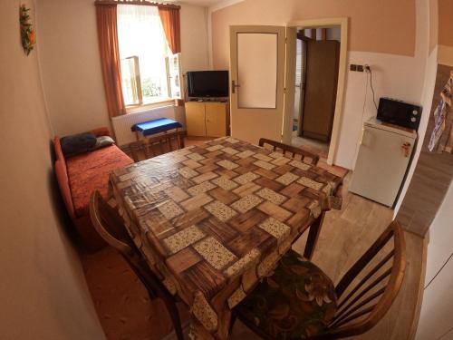 a kitchen and dining room with a table and a refrigerator at Pension V údolí v Jizerských horách in Josefuv dul