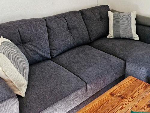 a gray couch with two pillows and a wooden table at 7 person holiday home in HUNNEBOSTRAND-By Traum in Hunnebostrand