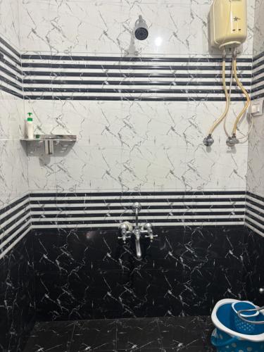 a black and white bathroom with a sink and a toilet at Thakshil homestay in Hampi