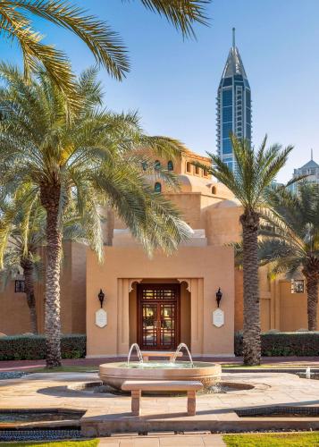 a building with palm trees in front of it at One&Only Royal Mirage Resort Dubai in Dubai