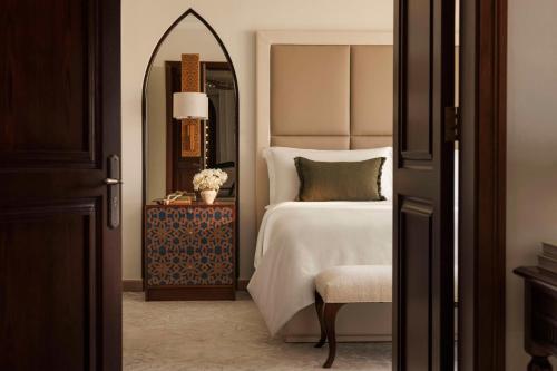 a bedroom with a bed and a mirror and a chair at One&Only Royal Mirage Resort Dubai in Dubai