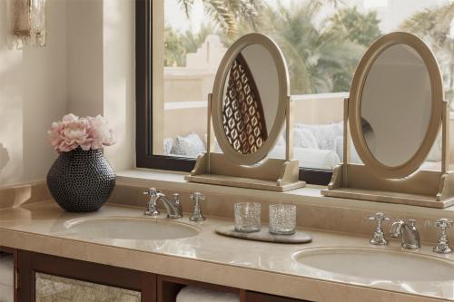 a bathroom with two sinks and two mirrors at One&Only Royal Mirage Resort Dubai in Dubai