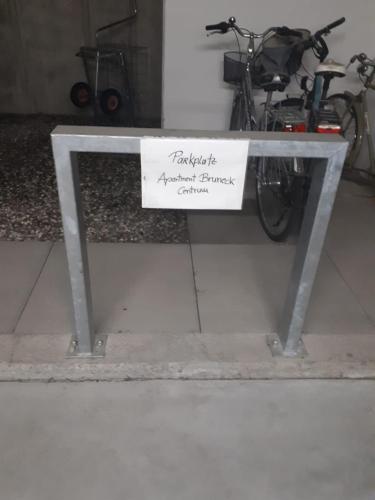 a sign on a bench with a bike parked next to it at Apartment Bruneck Central in Brunico