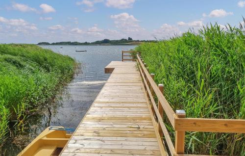 a wooden bridge over a river with a boat on it at Lovely Home In Sölvesborg With Kitchen in Sölvesborg