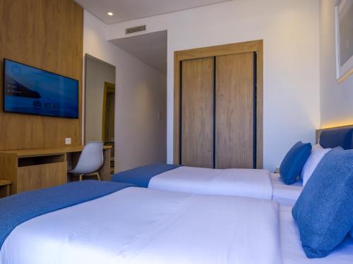 a hotel room with two beds and a tv at Valeria Kasbah Del Mar in Cabo Negro
