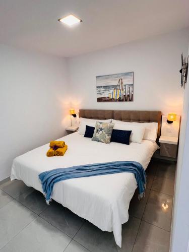 a bedroom with a large white bed with two lamps at Las Mareas Sea View Terrace 3 min to Beach in Morro del Jable