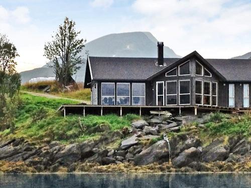 ein Haus auf einem Hügel neben einem Wasserkörper in der Unterkunft 11 person holiday home in Gullesfjord in Flesnes