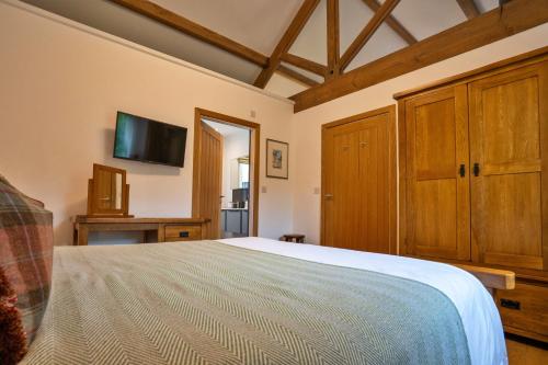 une chambre avec un lit et une télévision à écran plat dans l'établissement Finest Retreats - Westhills Cottage, à Winster