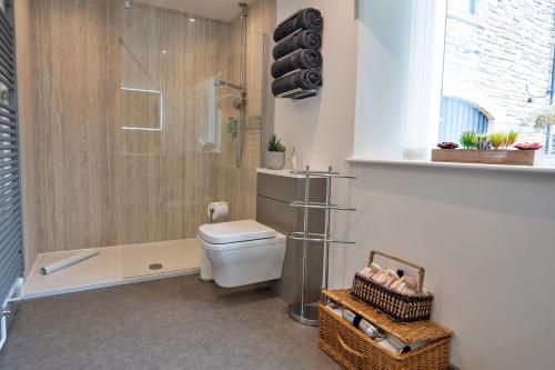 une salle de bain avec douche et toilettes dans une chambre dans l'établissement Finest Retreats - Westhills Cottage, à Winster
