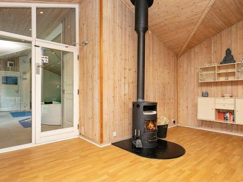 a wood burning stove in a room with wooden walls at 12 person holiday home in Væggerløse-By Traum in Marielyst