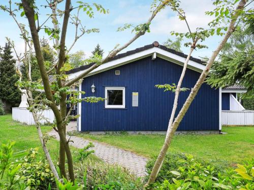 a blue house with a white window in a yard at 12 person holiday home in Væggerløse-By Traum in Marielyst