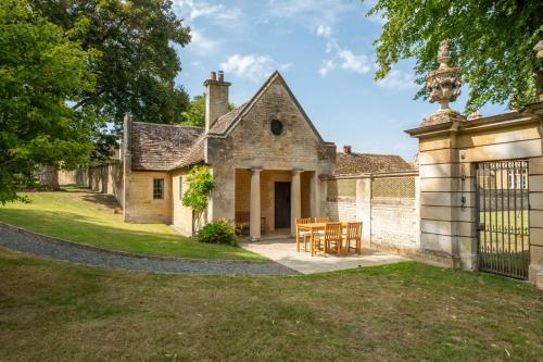 an old stone house with a table and chairs at The Gate House in Peterborough