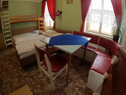 a bedroom with a desk and a bed and a table at Pension V údolí v Jizerských horách in Josefuv dul