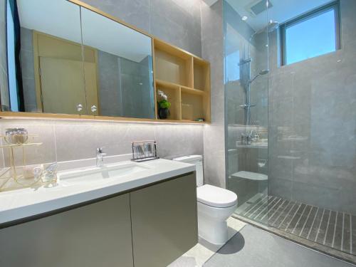 a bathroom with a sink and a toilet and a shower at Begonia Hotel in Sanya