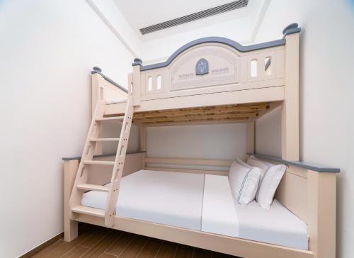 a bunk bed with a ladder in a room at Begonia Hotel in Sanya