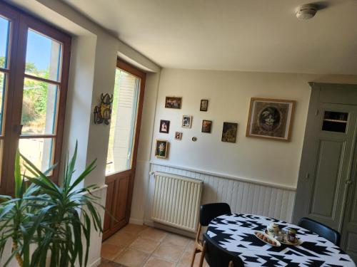 een eetkamer met een tafel en een plant bij la ferme du Planeau in Montchenu