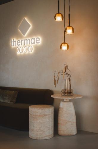 a table and two stools in front of a couch at Wellnesshotel Thermae 2000 in Valkenburg