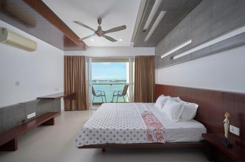 a bedroom with a bed with a ceiling fan at BayView Retreat Premium Stay at Marine Drive Kochi in Cochin