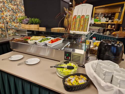 a buffet line with plates and bowls of food at Ferien Hotel Cottbus in Kolkwitz