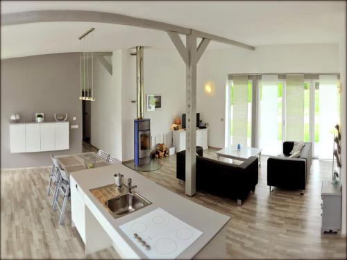 a kitchen and living room with a sink and a table at Family Escape with Garden in Abreschviller
