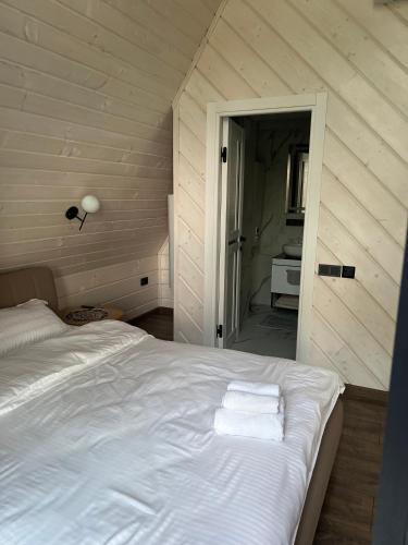 a bedroom with a bed with two towels on it at Aframe Shanti DreamDim in Svityazʼ