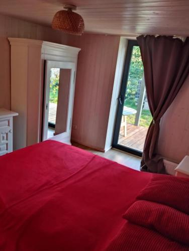 a bedroom with a red bed and a sliding glass door at Namelis soduose in Akademija