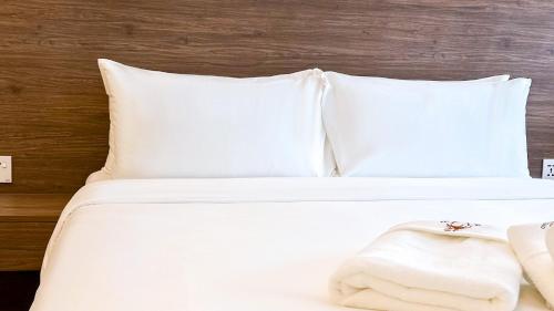 a white bed with white sheets and pillows at Cottonhouz by Ayuhouz in Kota Kinabalu