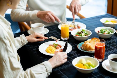 eine Gruppe von Menschen, die an einem Tisch sitzen und Frühstück essen in der Unterkunft Hotel Sierra Resort Hakuba in Hakuba