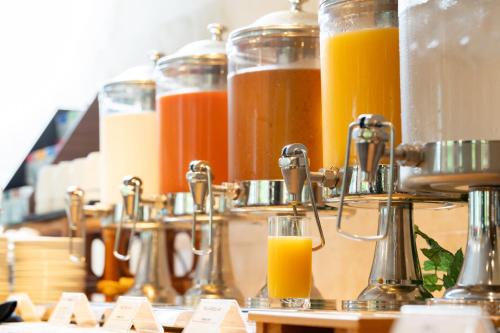 Eine Reihe von Orangensaftgläsern auf einer Theke in der Unterkunft Hotel Sierra Resort Hakuba in Hakuba