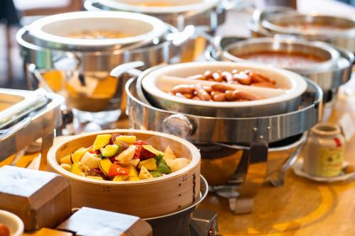 Ein Haufen Essen in Töpfen auf einem Tisch in der Unterkunft Hotel Sierra Resort Hakuba in Hakuba