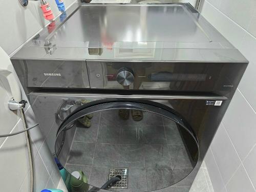 a washing machine with a glass door in a room at Haenggung-dong Stay in Suwon