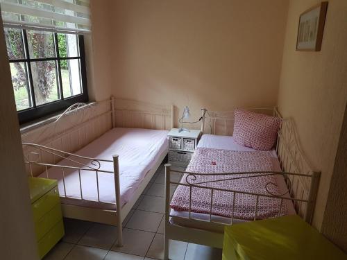 een kleine slaapkamer met twee bedden en een raam bij Group Hideaway with Pool in Ballenstedt