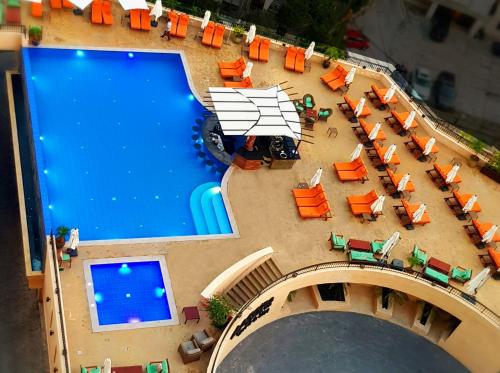 an overhead view of a pool with tables and chairs at BURJ ON BAY Hotel in Jounieh