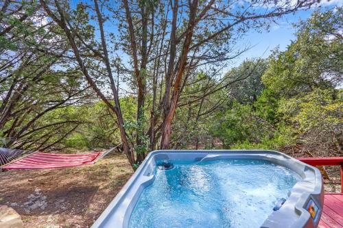 a jacuzzi tub in a yard with trees at Cozy Cabin in Wimberley