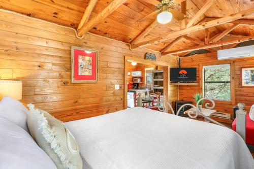 a bedroom with a bed in a room with wooden walls at Cozy Cabin in Wimberley