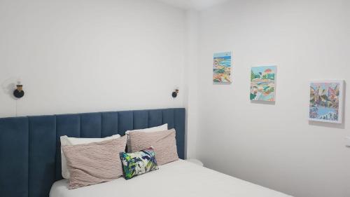 a bed with a blue headboard and two pillows at Romantic Downtown Studio in Vila do Conde