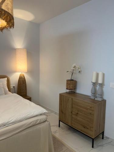 a bedroom with a bed and a wooden dresser at PMT22 - Luxury villa with private heated pool and jacuzzi in Torrevieja