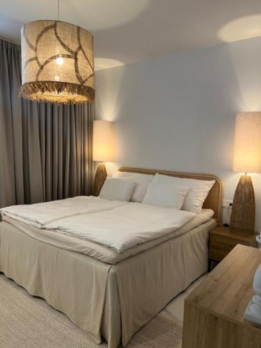 a bedroom with a bed and a chandelier at PMT22 - Luxury villa with private heated pool and jacuzzi in Torrevieja