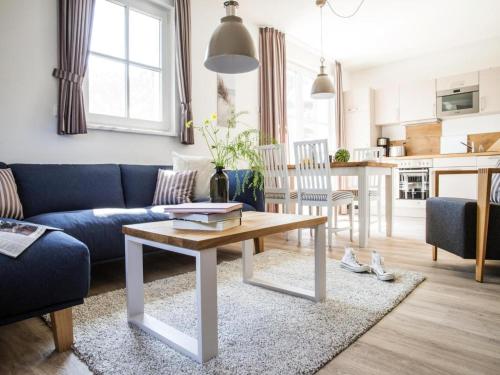 a living room with a blue couch and a table at Apartment, Zingst in Zingst
