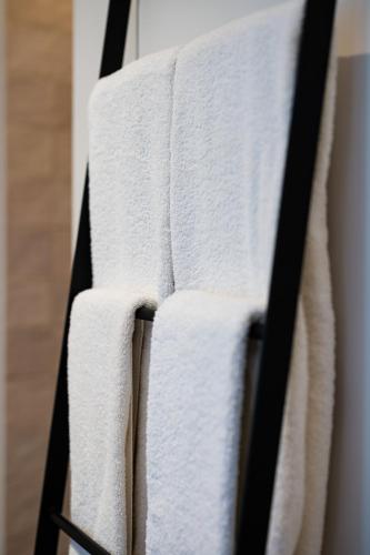 a group of white towels hanging on a rack at Poutrelle Guestrooms in Bruges
