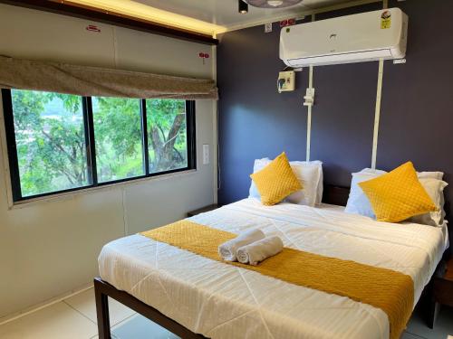 a bedroom with a bed with yellow pillows at Natural Lake Pawna in Lonavala