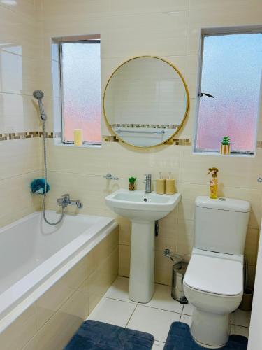 a bathroom with a sink and a toilet and a mirror at Beautiful Luxury Apartment in Johannesburg