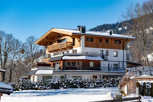 a large building with snow in front of it at Tirol Chalet Brixen in Brixen im Thale