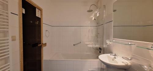 a bathroom with a sink and a bath tub and a sink at Prémiový apartmán s privátní saunou a terasou v blízkosti Lipenské nádrže a lyžařského střediska in Lipno nad Vltavou