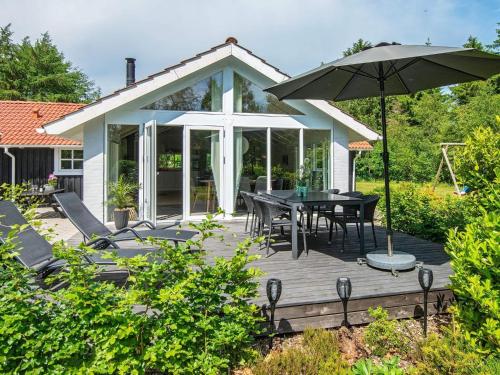 a wooden deck with a table and an umbrella at 6 person holiday home in Højslev-By Traum in Højslev