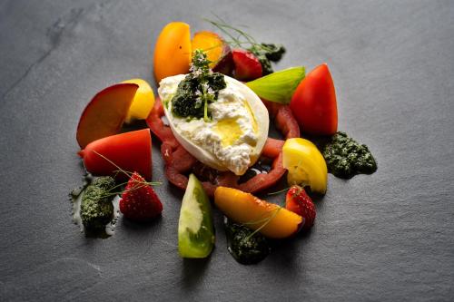 a plate of food with an egg and fruits and vegetables at Brugger's Genießerhotel Lanersbacherhof in Tux