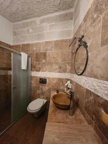 a bathroom with a sink and a toilet and a shower at Sinasos Palace Cave Hotel in Urgup