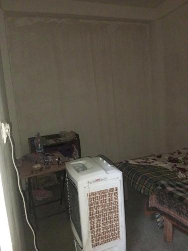 a room with a room with a bed and a microwave at Nirbhay home in Kānpur