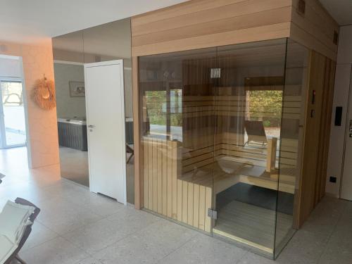 a glass wall in a living room with a chair at Apartamenty na Wydmach z widokiem in Pobierowo