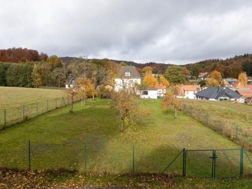 a field with a fence and trees in it at Ferienhaus im Thüringer Wald in Wutha-Farnroda